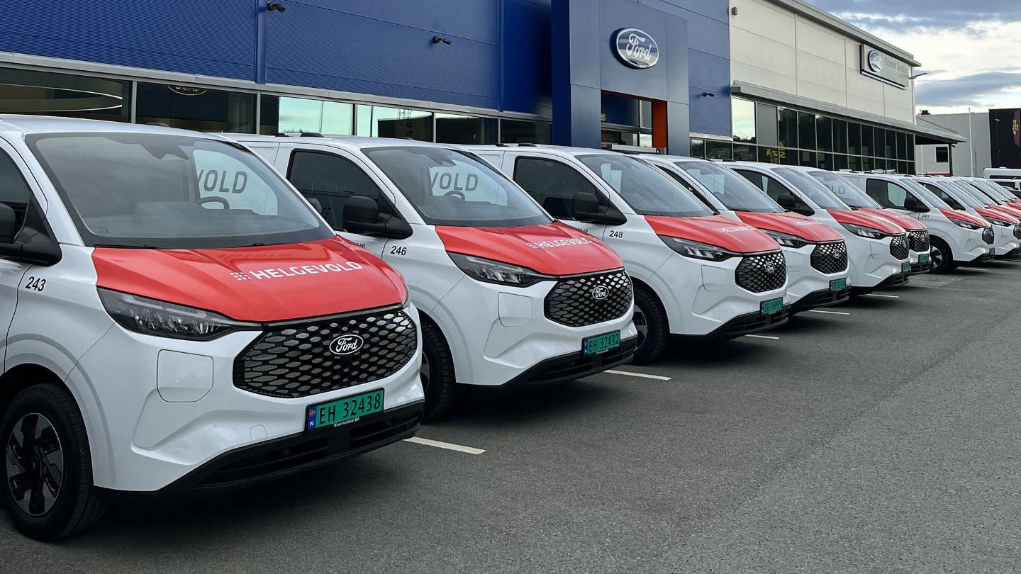 En rekke med E-Transit Custom foran en Ford-forhandler