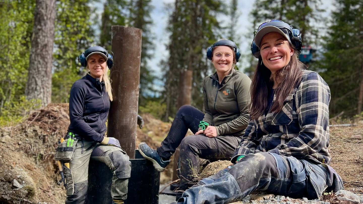 Jentene i OssTRE i arbeidsklær ute i skogen.
