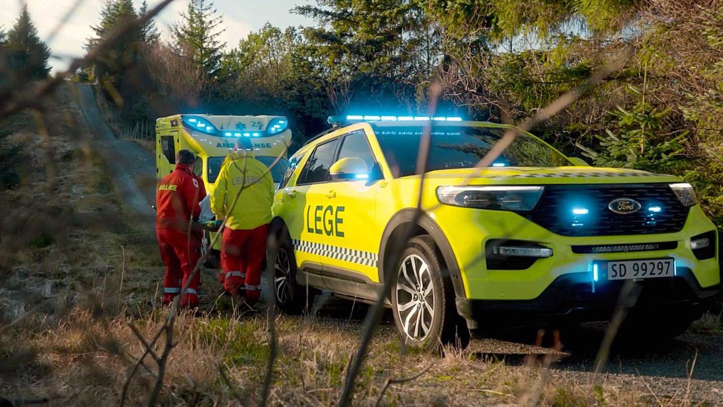 Paramedics next to Ford Explorer in the woods