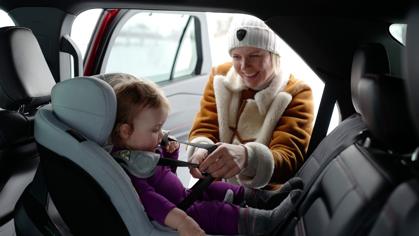 Happy woman inside a car with baby
