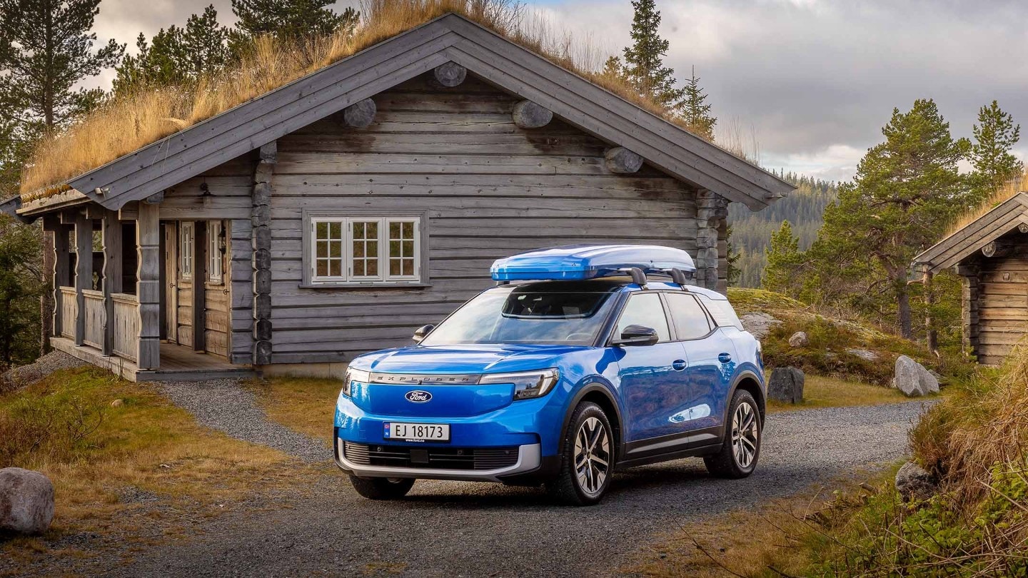 Blå Explorer med takboks står foran en fjellhytte