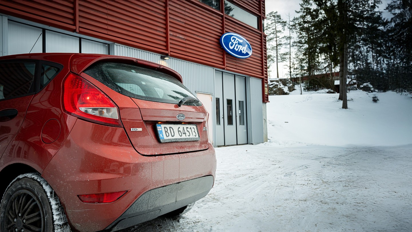 Nærbilde av en rød Ford Fiesta bakfra utenfor et Ford-verksted
