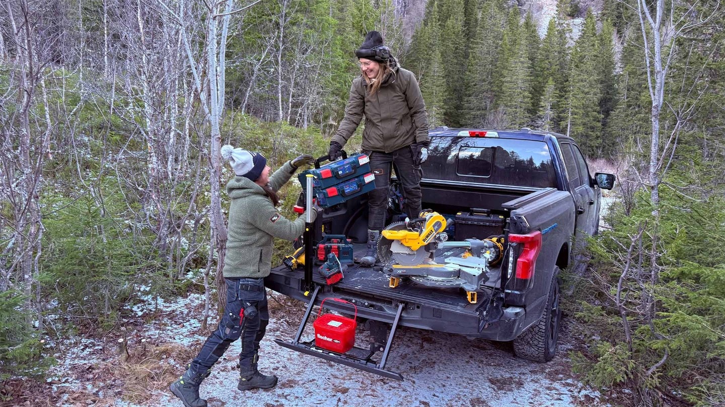 To av jentene i OssTre laster av verktøy fra planen på F-150 Lightning.