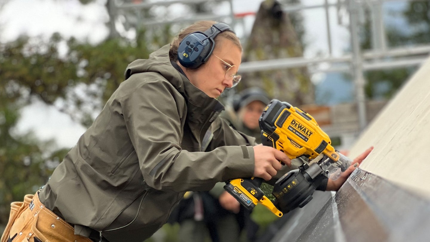 Maria i OssTre bygger taket på hytta.