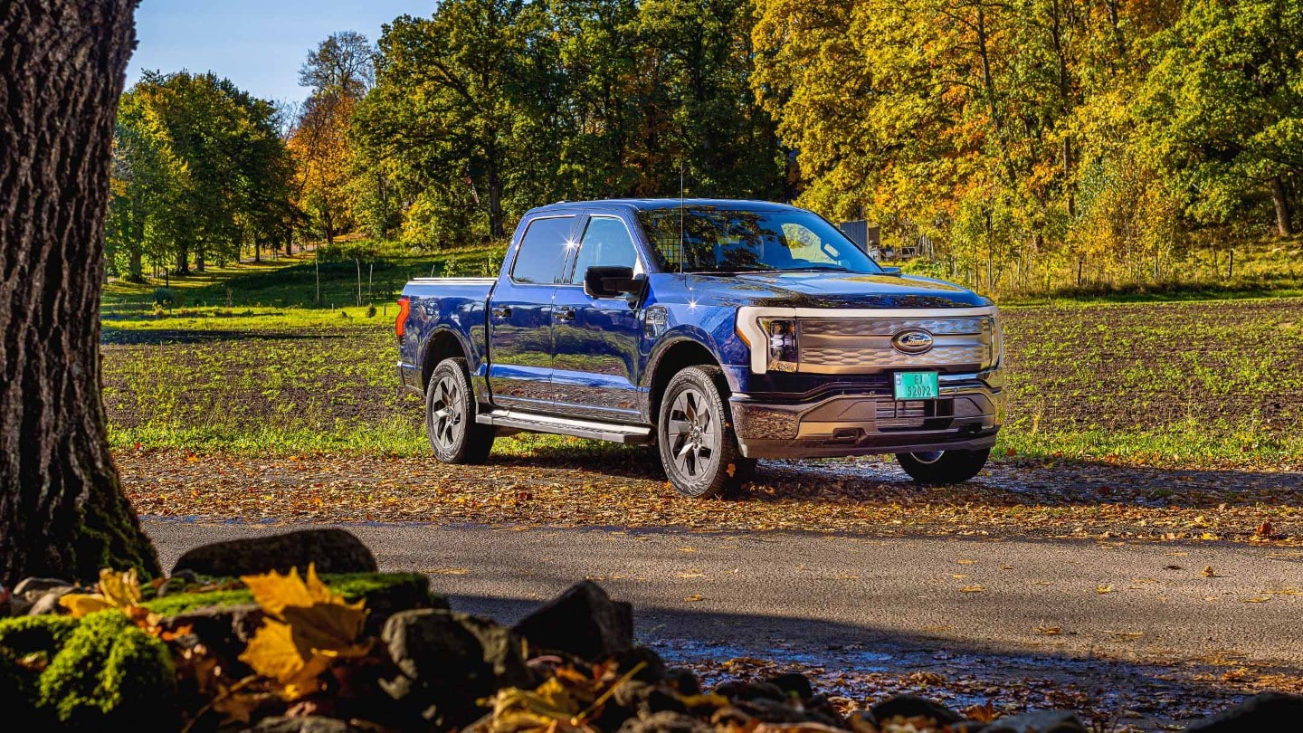Eksteriørt bilde av en blå F-150 Lightning i flott høstvær.