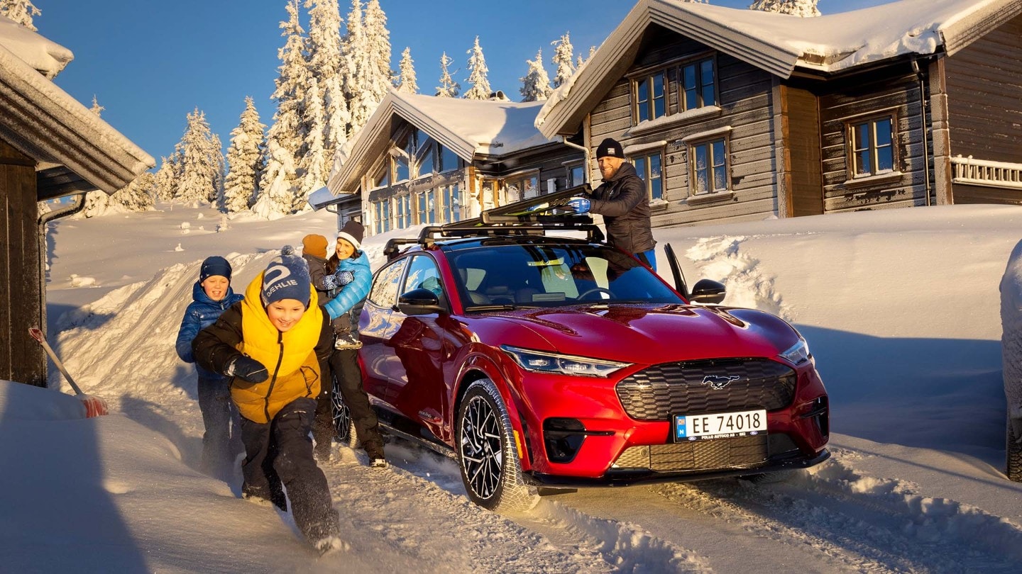 Mustang Mach-e with family playing in snow