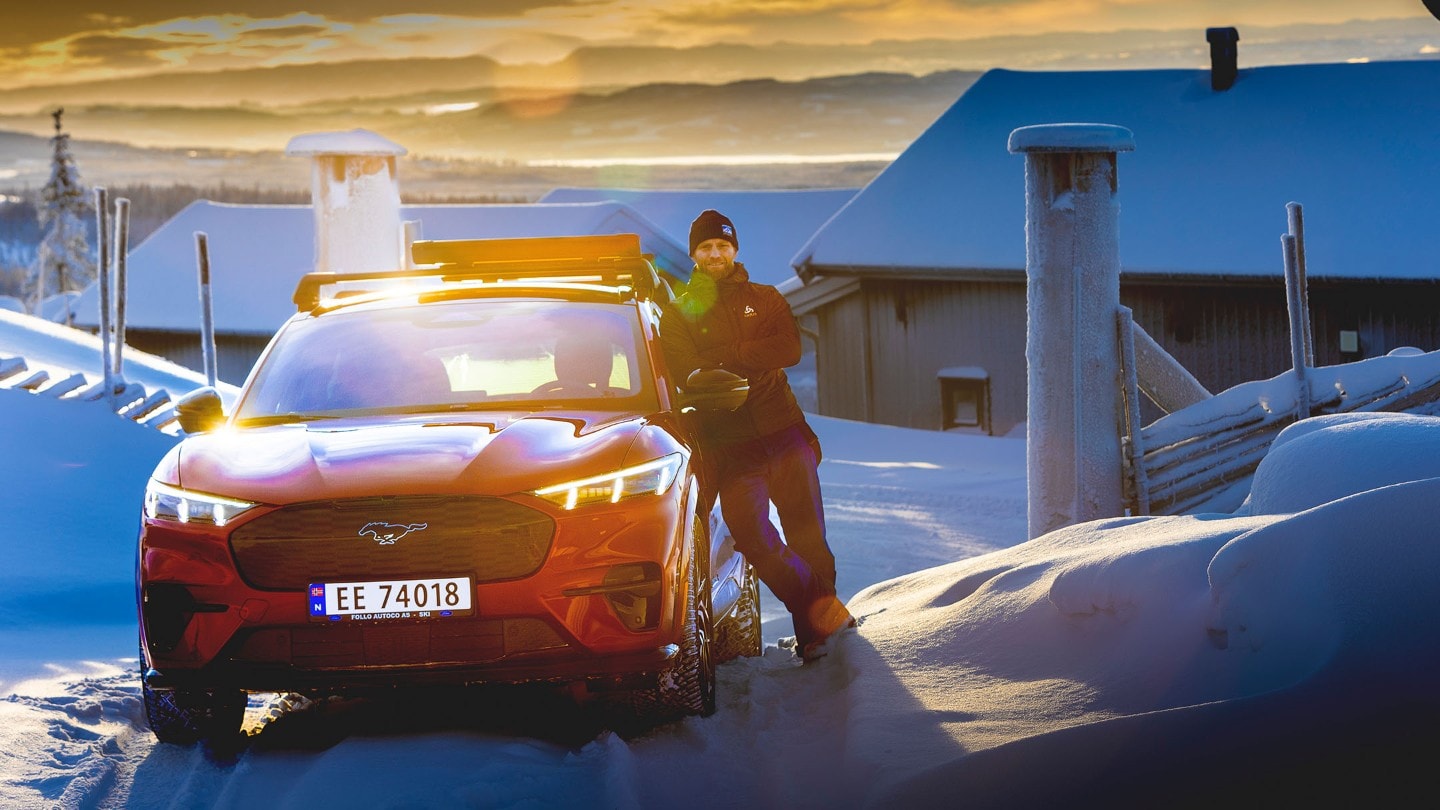 Man with Mustang Mach-E in sunset winter
