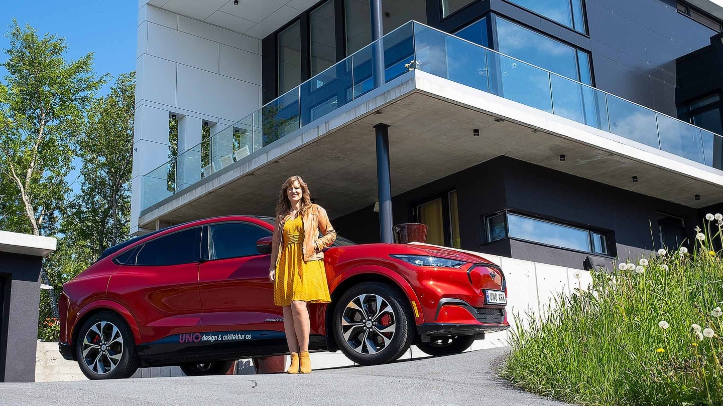 A woman standing next to Mustang Mach-E