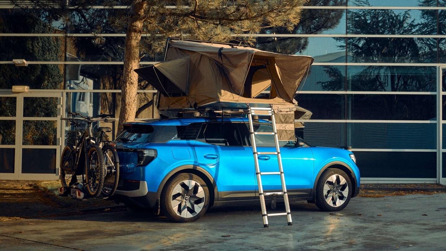 Blå helelektrisk Ford Explorer med taktelt og sykkelstativ.