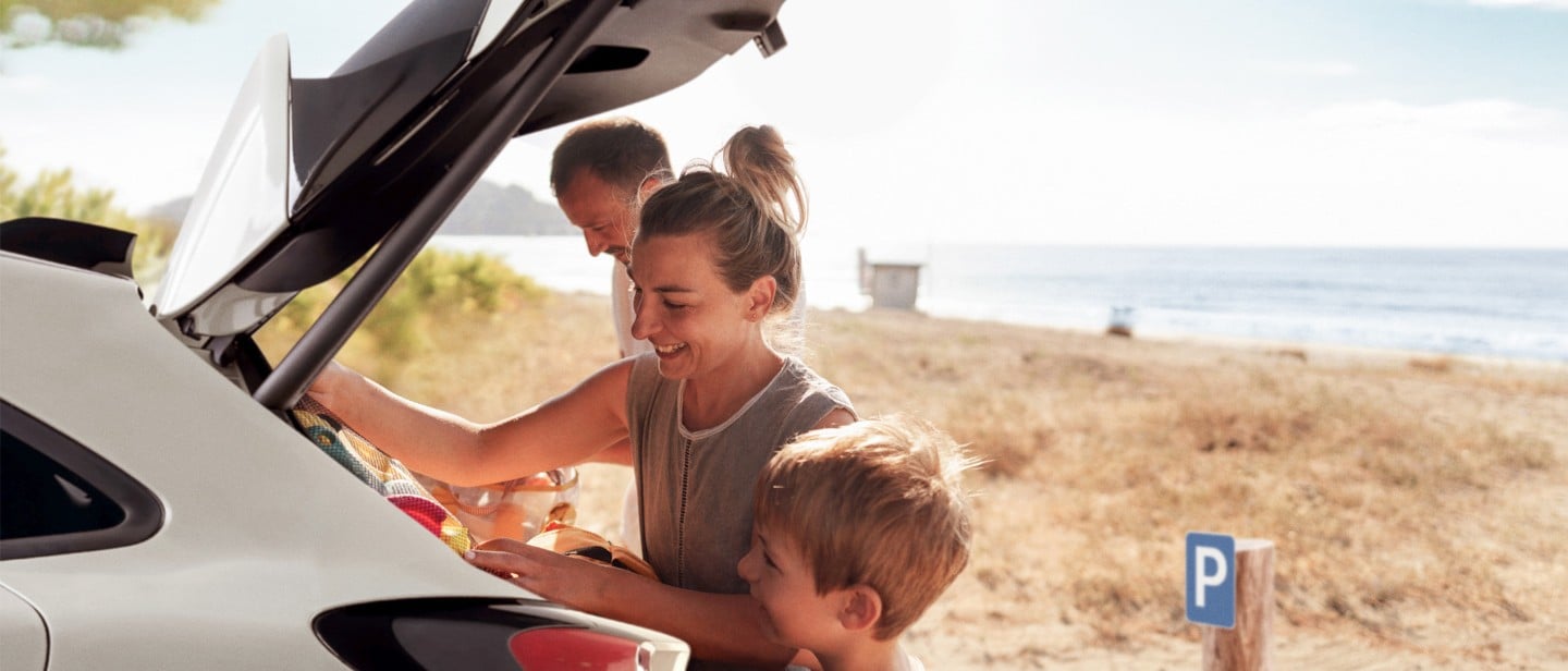 Familie som pakker bagasjerommet på en Ford. 