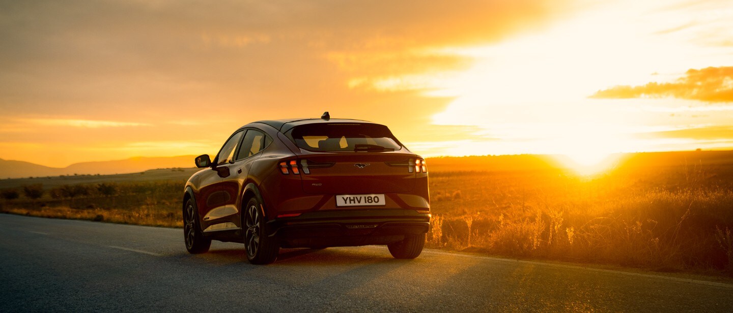 Red Mustang Mach-E Premium AWD driving on the road