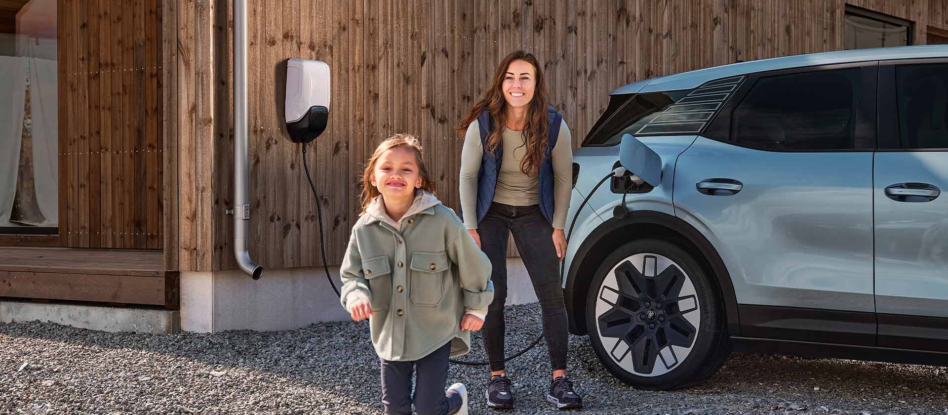  En familie som har det gøy mens de lader sin helelektriske Ford Explorer med en hjemmelader.