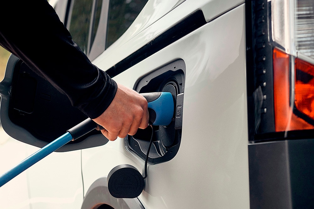  En person som kobler til en Fords elektriske bil til en ladekabel.