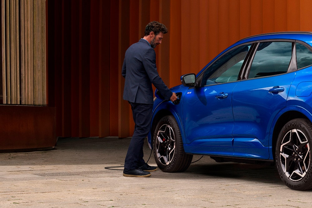  En person som kobler Ford plug-in hybridbil til en hjemmelader.