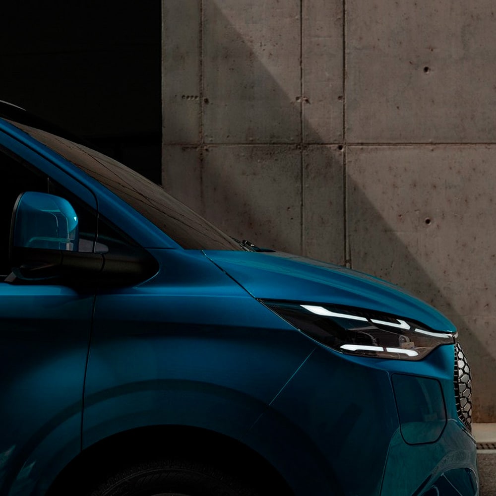  Nærbilde av en blå Ford elektrisk varebil.