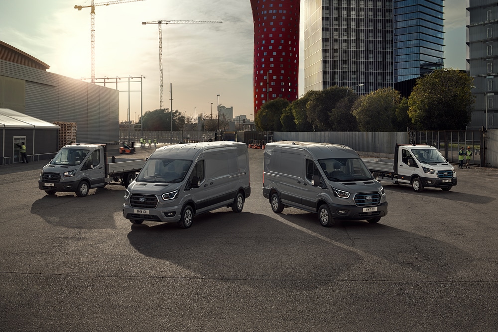 Utvalget av Ford elektriske og plug-in-hybrid-varebiler parkert ute på en parkeringsplass.