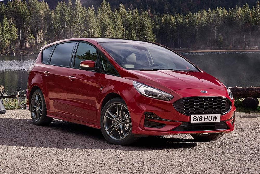 En rød Ford S-Max parkert ved en innsjø omgitt av skog, sett fra front i trekvartsvinkel.