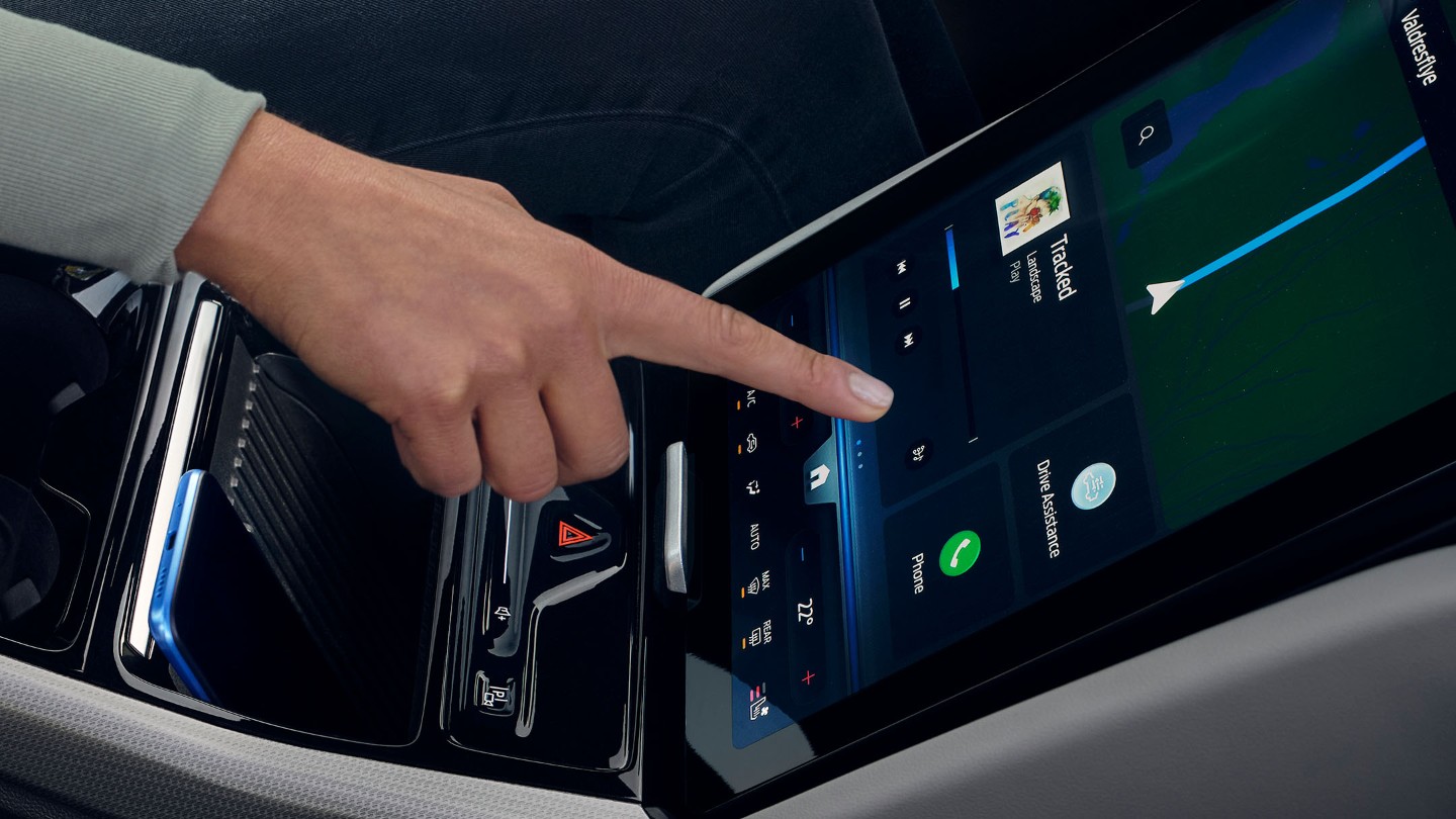 En kvinne som samhandler med den store SYNC-touchskjermen i Ford Explorer. 
