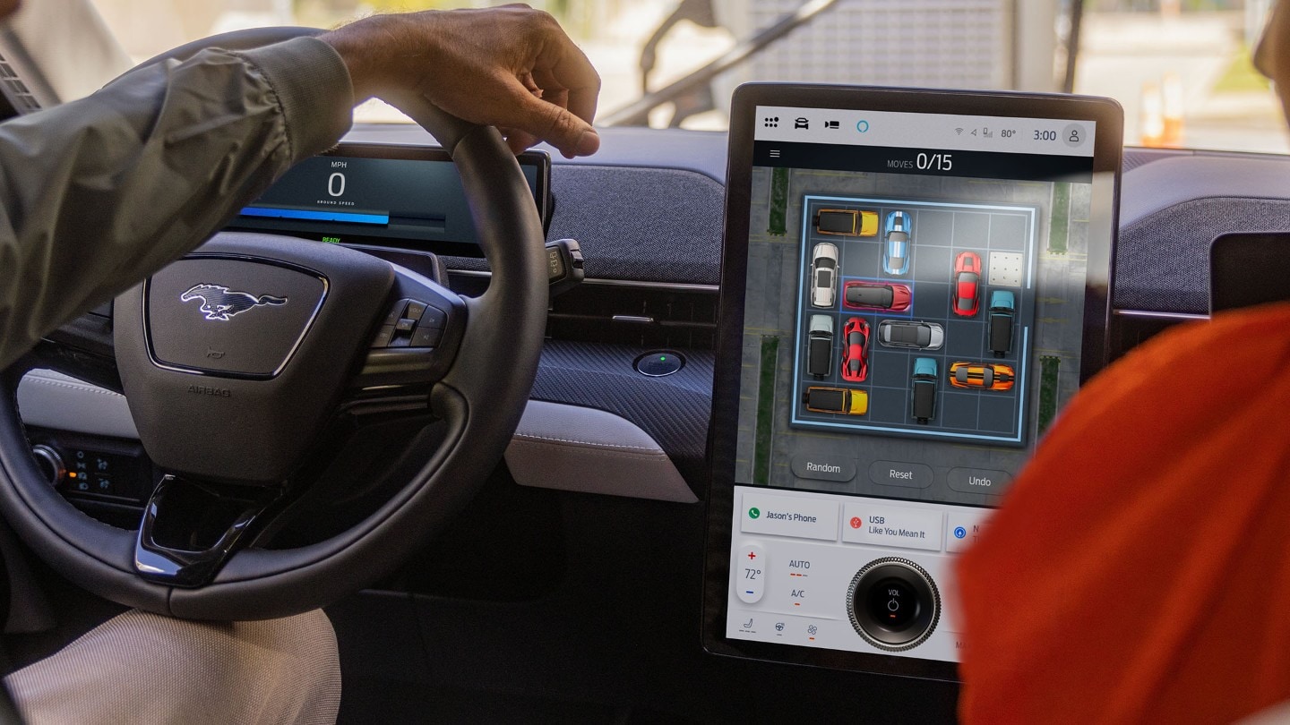 Interiøret i Ford Mustang Mach-E, som viser rattet og den store SYNC-touchskjermen.