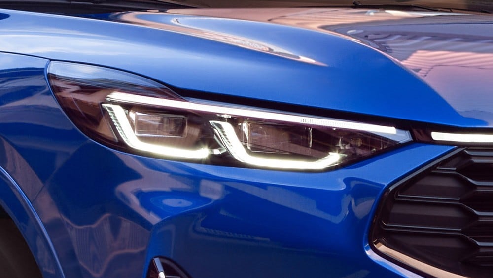 Et nærbilde av frontlyktene på en blå Ford Mustang Mach-E.