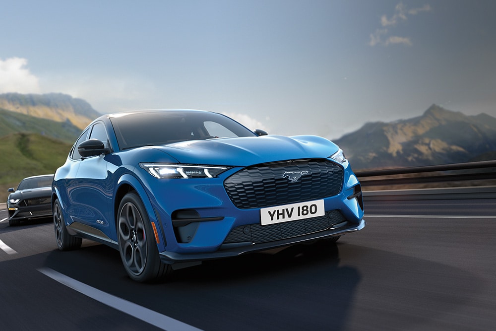 En blå Ford Mustang Mach-E som kjører  på en motorvei