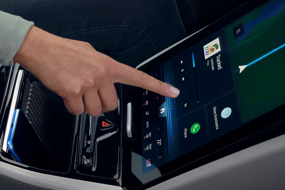 En kvinne som samhandler med den store SYNC-touchskjermen i Ford Explorer. 