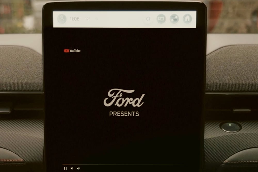 Et nærbilde av den 15,5-tommers SYNC 4-touchskjermen med en grafikk som lyder «Ford presenterer», som demonstrerer strømming av video i bilen
