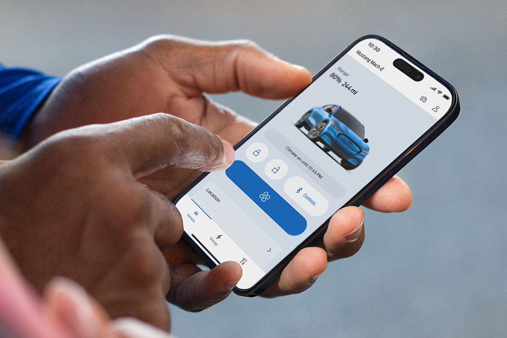 Et nærbilde av en iPhone som viser FordPass app, med en grafikk av en Ford Mustang Mach-E og flere app-knapper.