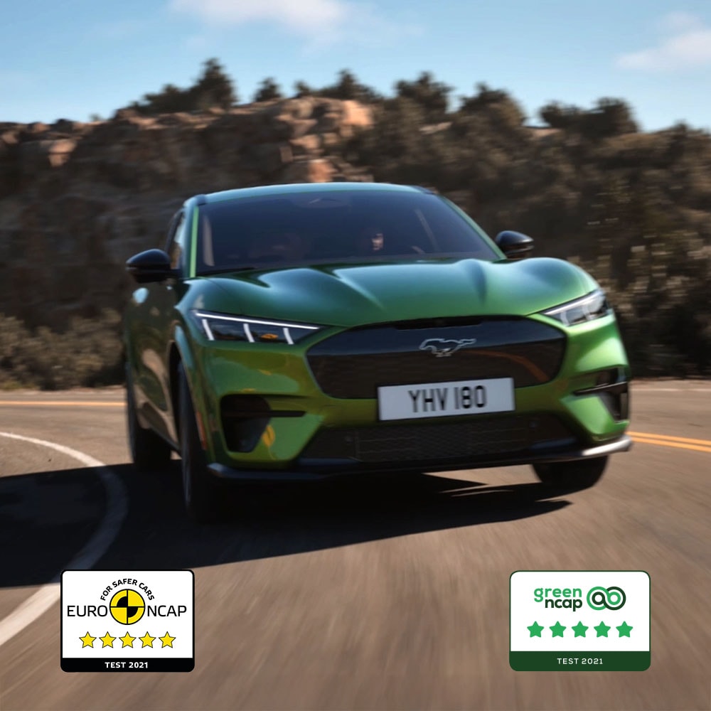 En Ford Mustang Mach-E GT i Eruption Green som kjører på en fjellvei.