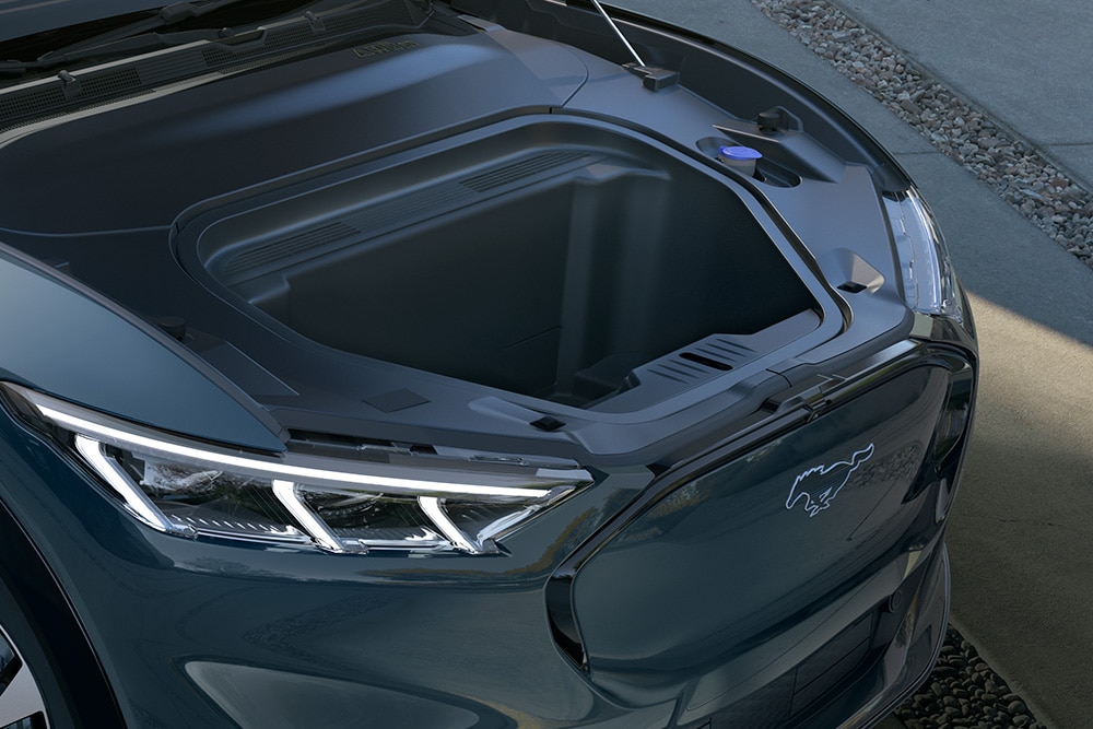 En person som plasserer en bag i frunken på en Ford Mustang Mach-E.
