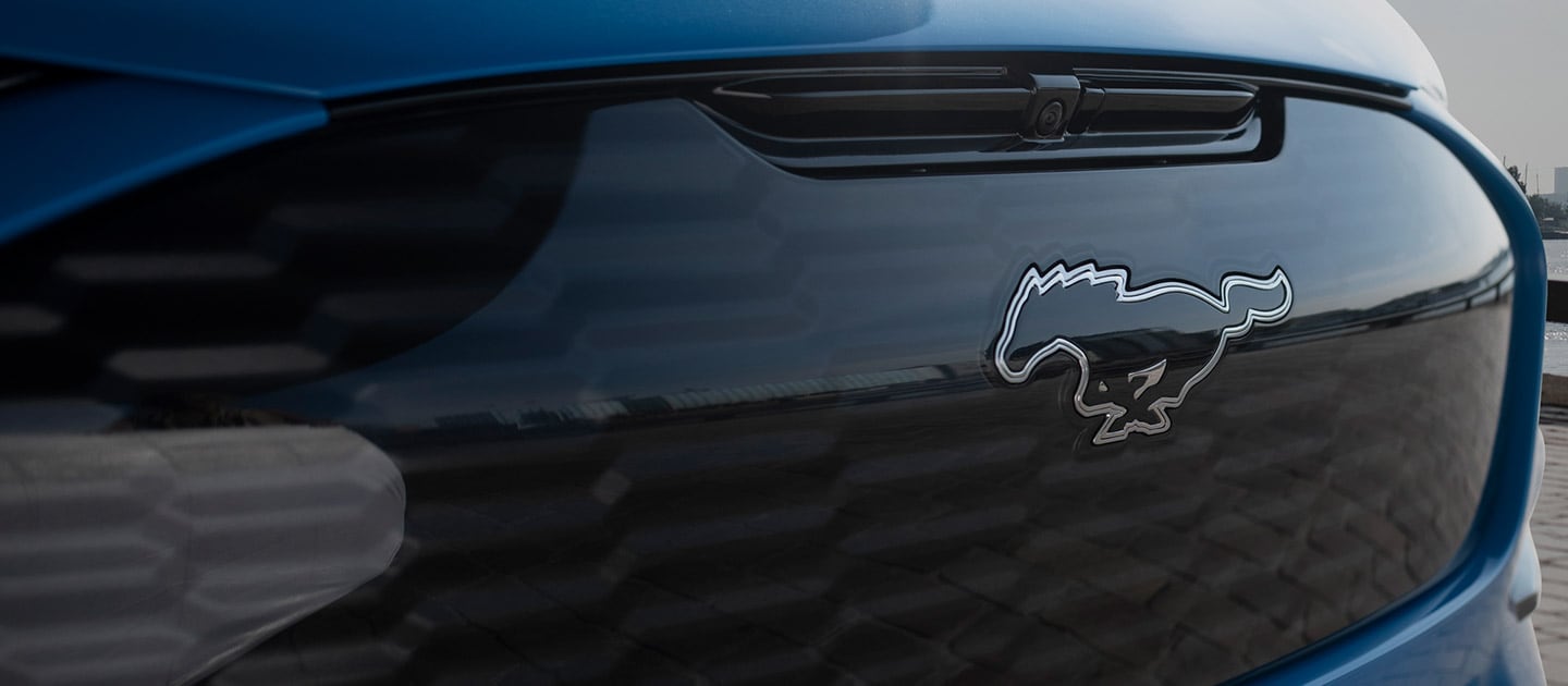 Nærbilde av Ford Mustang Mach-E logo i grillen. 