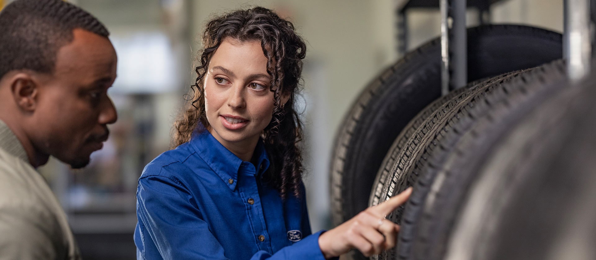 En Ford-reparasjonspesialist hjelper en kunde med nye Fiesta-bildekk.