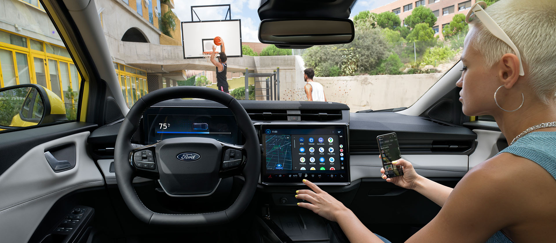 Interiøret i Ford Puma®, med en person som synkroniserer mobiltelefonen til den store touchskjermen trådløst.