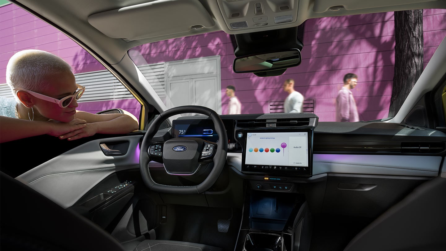 Person som ser på interiøret i nye Ford Puma®, som viser den store touchskjermen og stemningsbelysningen.