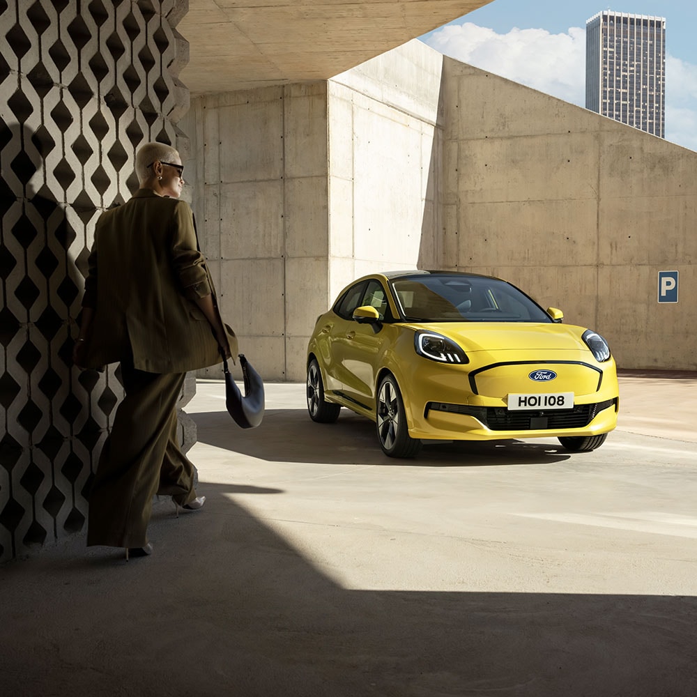 En person går mot nye elektriske Ford Puma® i gult.