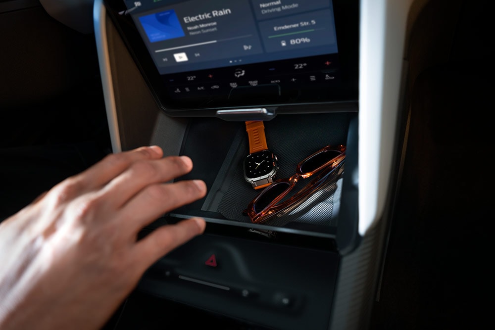 En hånd strekker seg mot My Private Locker-rommet i Ford Capri®, som viser en klokke og et par solbriller på innsiden.