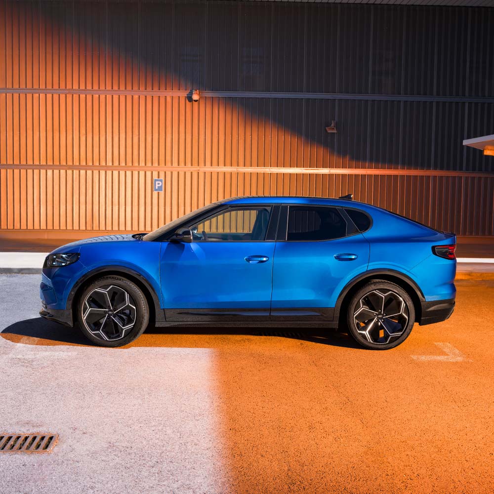 En blå Ford Capri vist fra siden. Euro NCAPs 5-stjerners sikkerhetsrating for 2024 vises i hjørnet øverst til høyre.