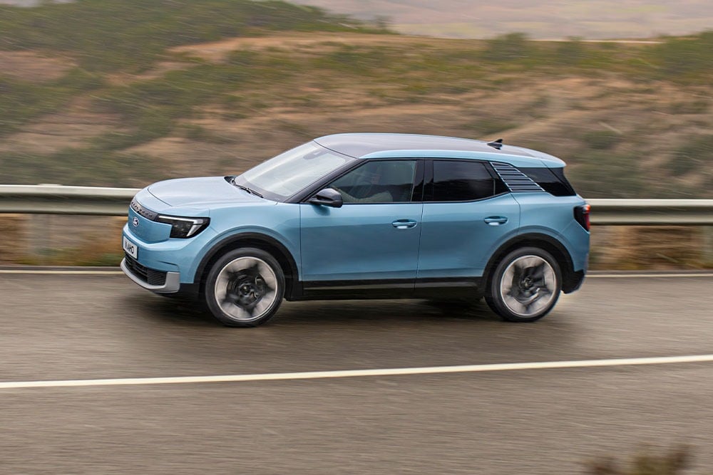 En blå Ford Explorer som kjører på en fjellvei 