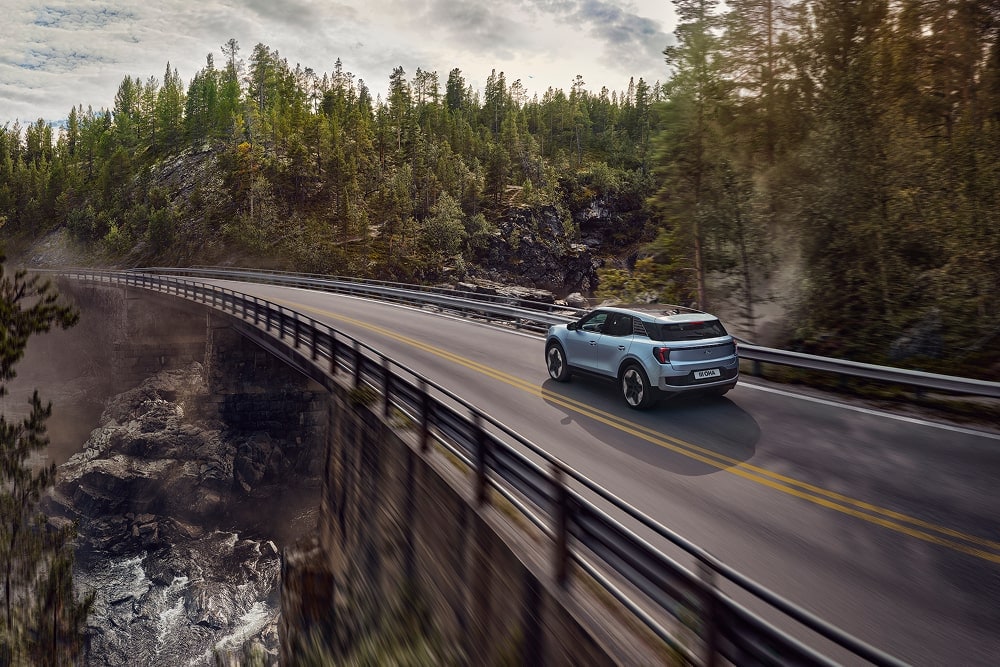 En blå Ford Explorer-familie-SUV som kjører gjennom et fjellandskap.