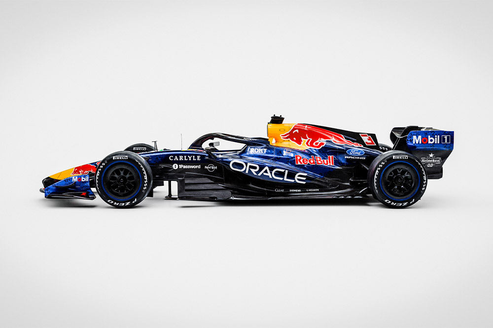 En elegant Red Bull Ford Formel 1 racerbil på en ren hvit bakgrunn med sponsorlogoer Ford og Red Bull.