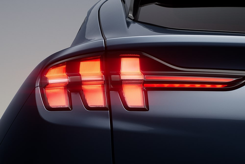 Nærbilde av opplyste, triple baklykter på en Ford Mustang Mach-E-sportsbil.