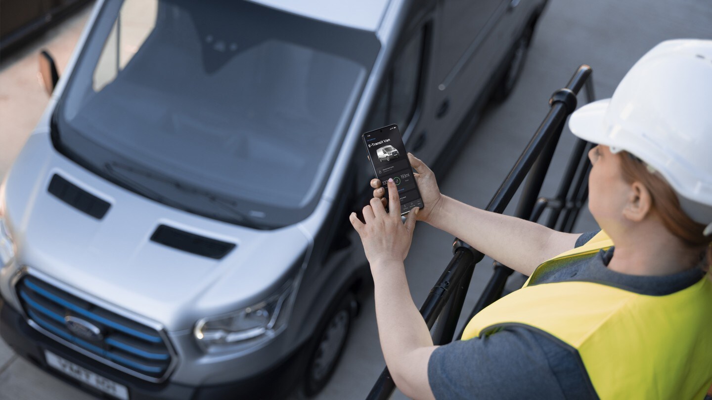 E-Transit external view with construction worker using the FordPass Pro app