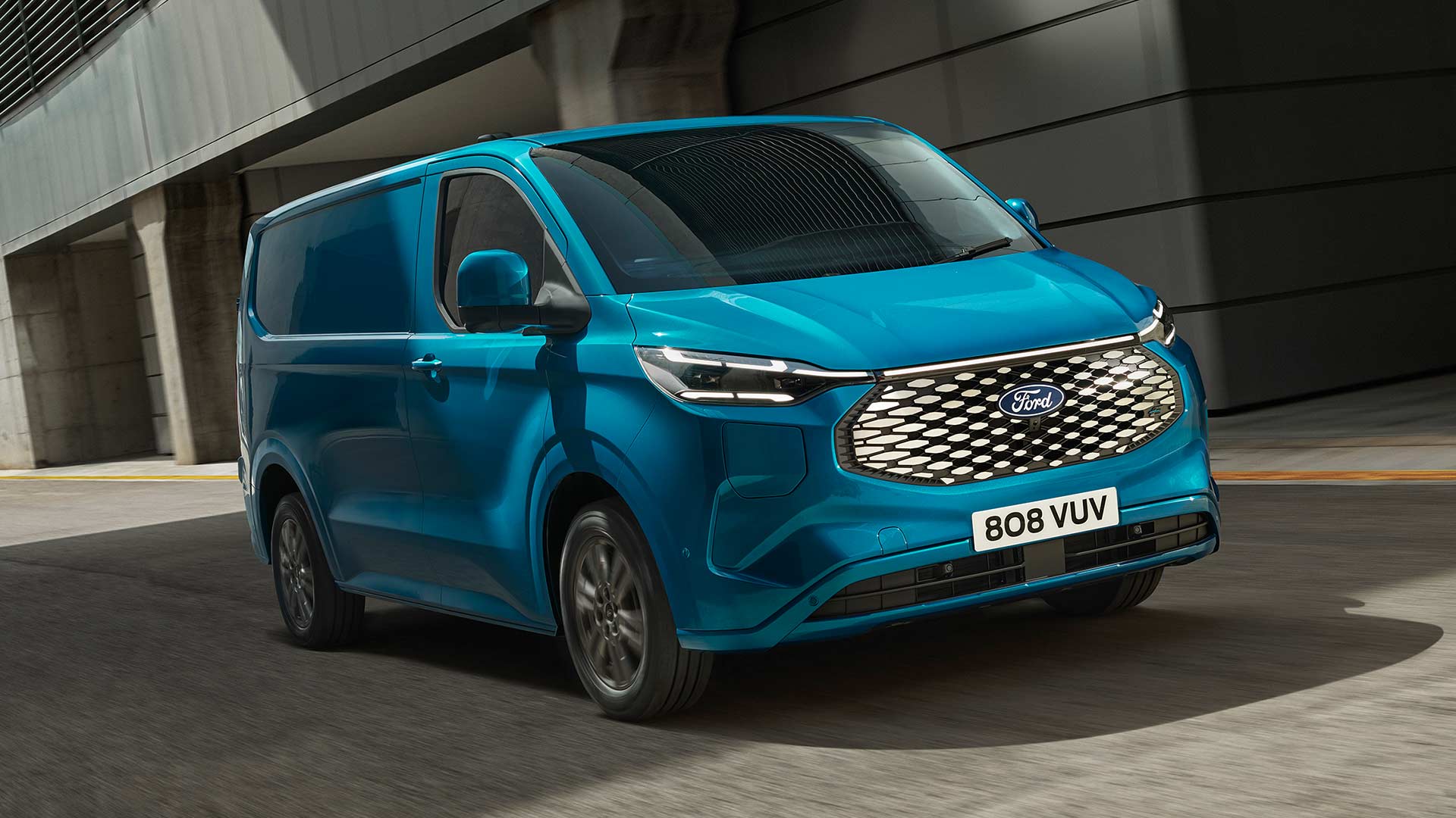 Blå elektrisk Ford E-Transit Custom-varebil som kjører.