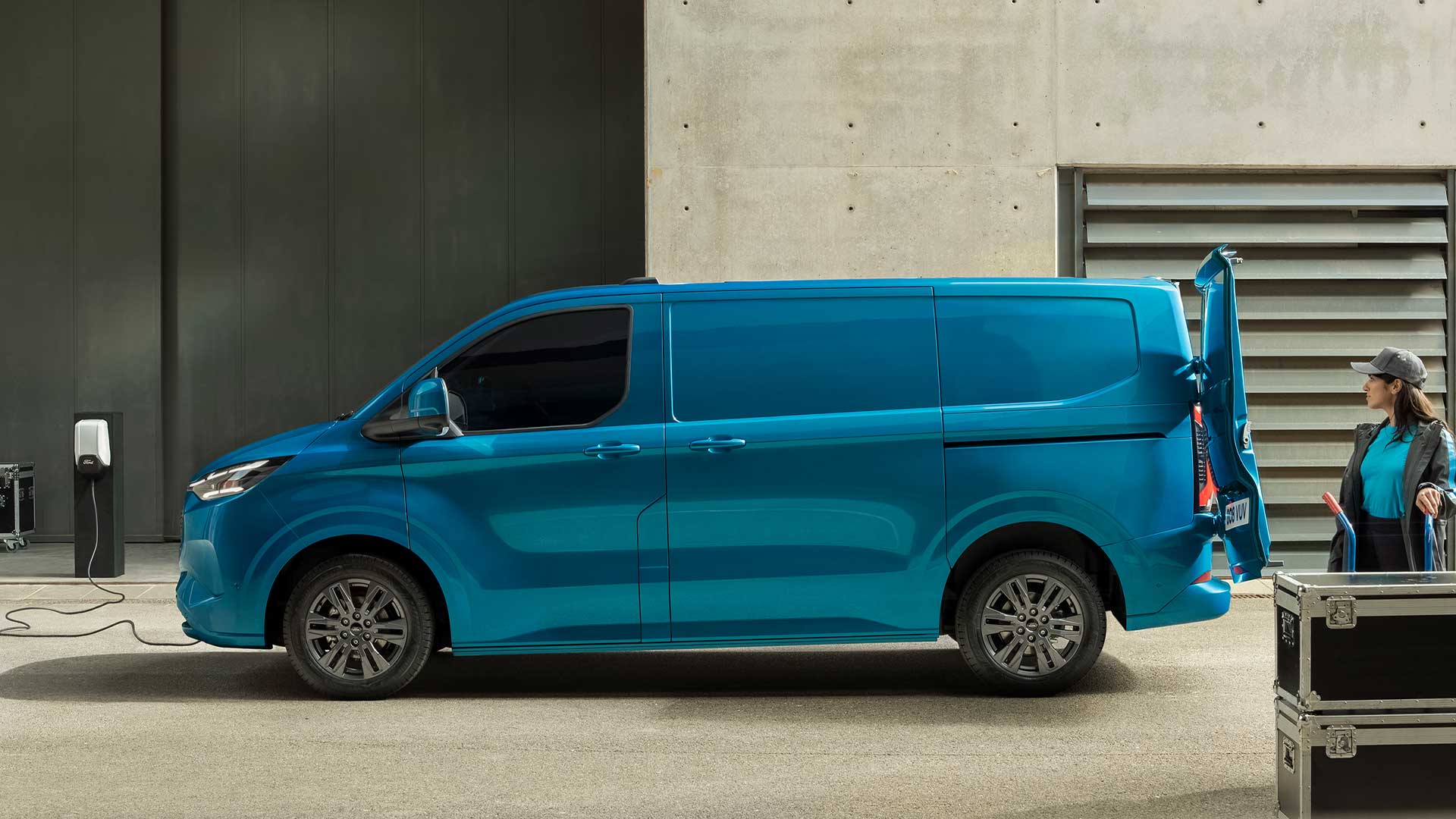 Blå elektrisk Ford E-Transit Custom-varebil som lader.