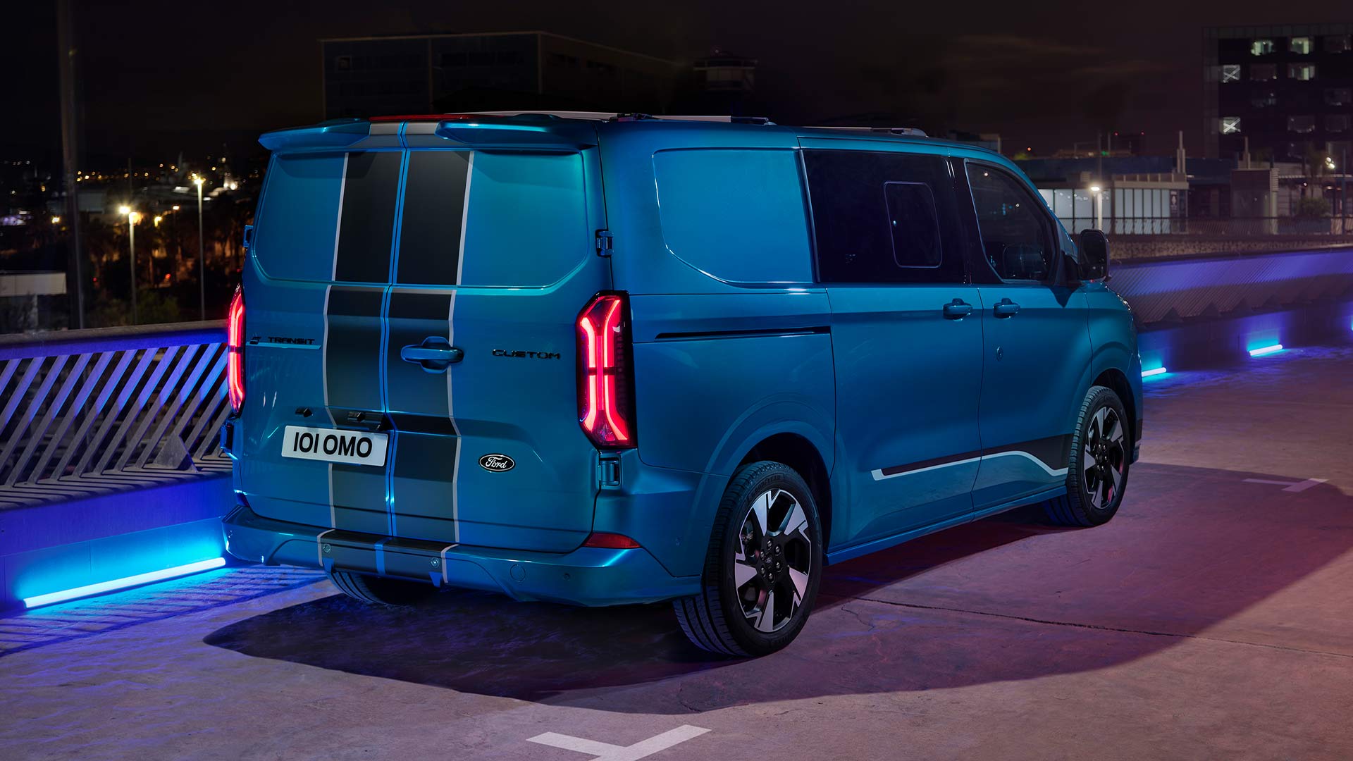 Bla elektrisk Ford E-Transit Custom Sport dobbelkabin varebil vist bakfra.