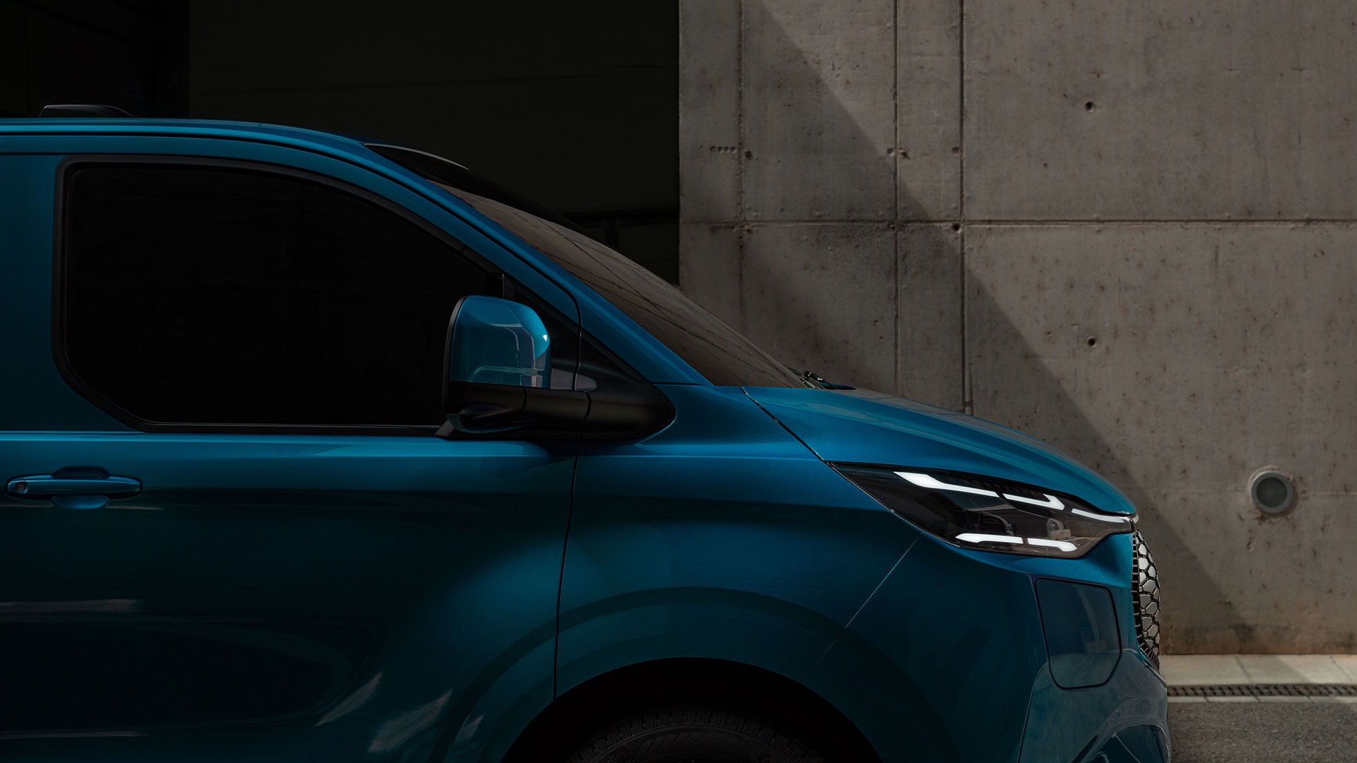 Nærbilde av LED-frontlys på blå Ford E-Transit Custom.