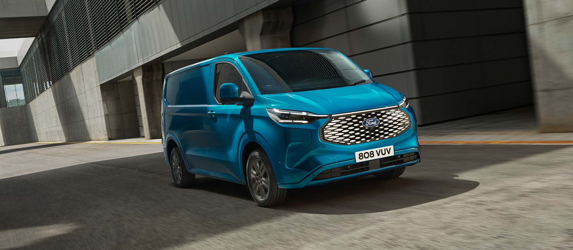 Blå elektrisk Ford E-Transit Custom-varebil, vist fra siden.
