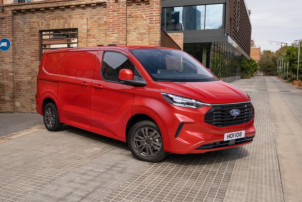 Rød Ford Transit Custom-varebil parkert på en gate.