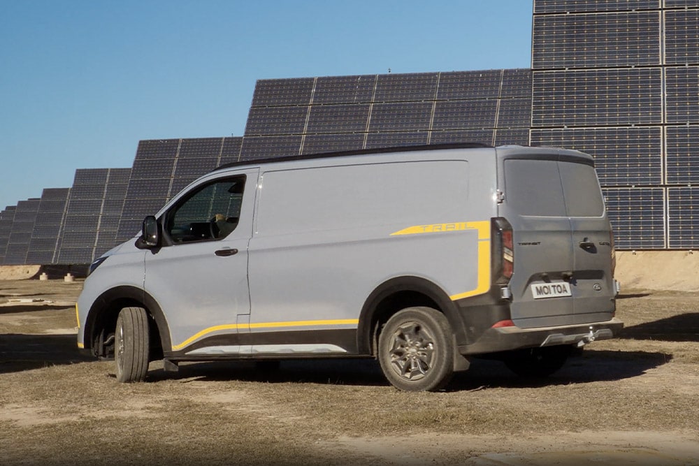 Grå Ford Transit Custom Trail-varebil med gule striper.