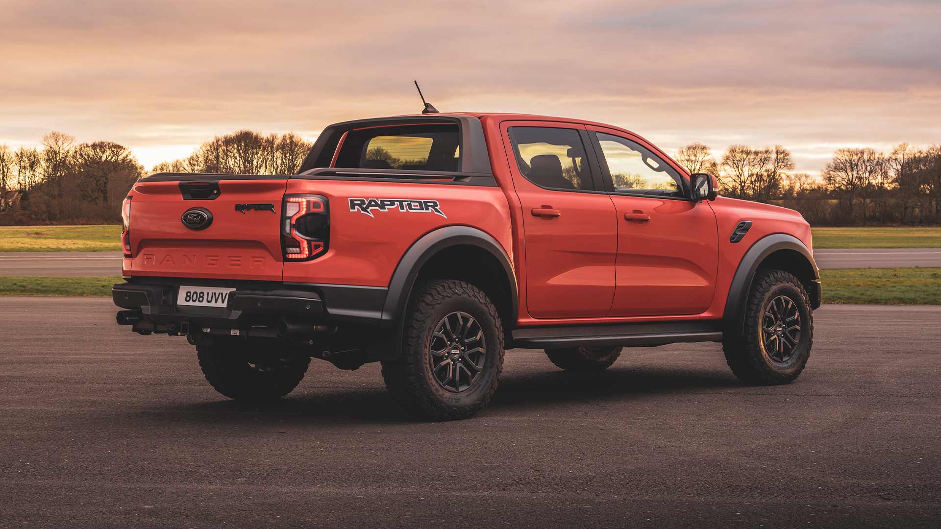 Ford Ranger Raptor i fargen Code orange sett bakfra parkert på en bane.